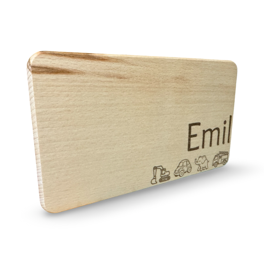 Schräge Ansicht eines personalisierbaren Kinder-Frühstücksbrettes aus Holz mit Lasergravur „Emil“ und niedlichen Motiven wie Bagger, Auto, Elefant und Feuerwehr