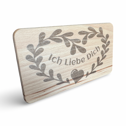 Schräge Ansicht eines personalisierbaren Frühstücksbrettes aus Holz mit Lasergravur „Ich Liebe Dich" und Herz