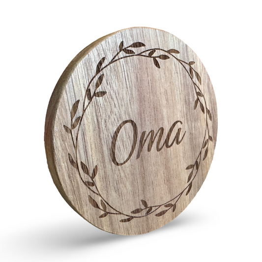 Schräge Ansicht eines Untersetzers aus Holz mit lasergraviertem Schriftzug „Oma"  – individualiserbarer Name - dekorativer Getränkeuntersetzer