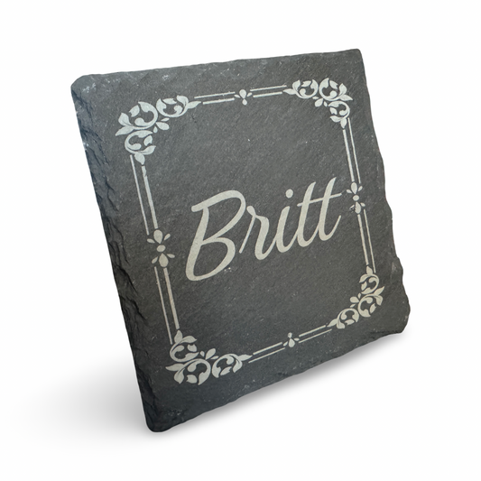 Schräge Ansicht eines Untersetzers aus Schiefer mit lasergraviertem Schriftzug „Britt"  – individualiserbarer Name - dekorativer Getränkeuntersetzer