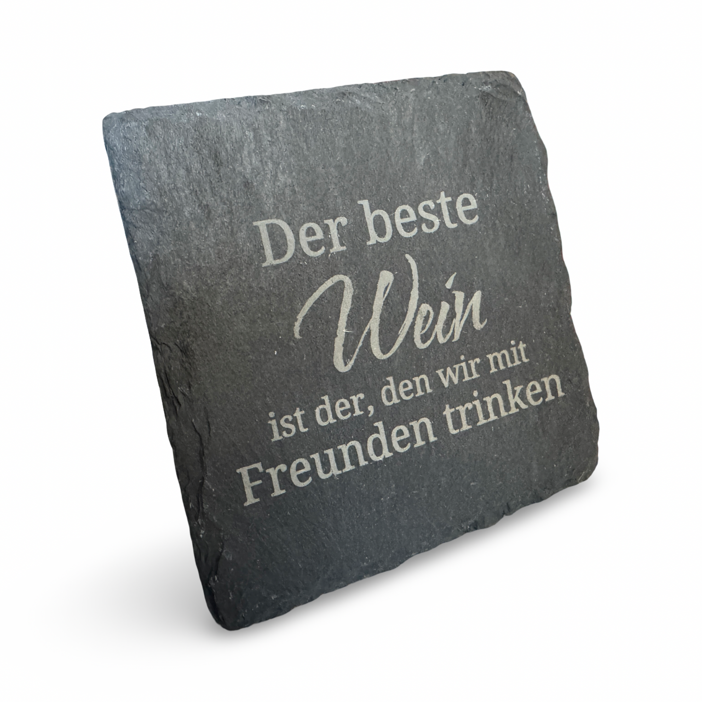 Schräge Ansicht eines Untersetzers aus Schiefer mit lasergraviertem Schriftzug „Der beste Wein ist der, den wir mit Freunden trinken“ – dekorativer Getränkeuntersetzer für Weinliebhaber